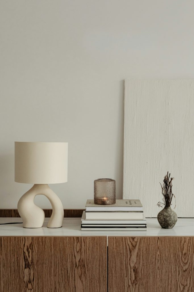 A table lamp beside a stack of books.