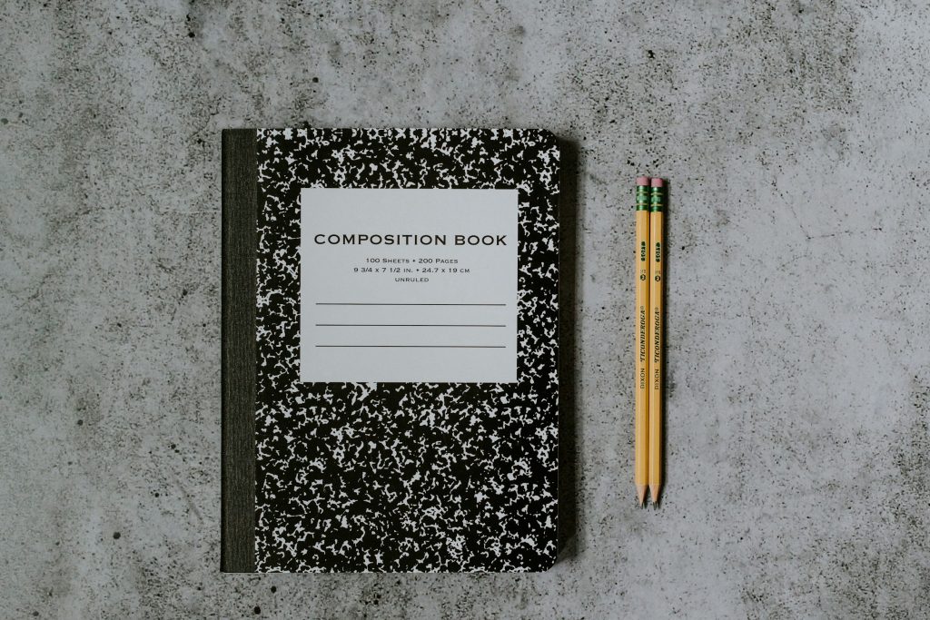 A notebook and pencils on a table.